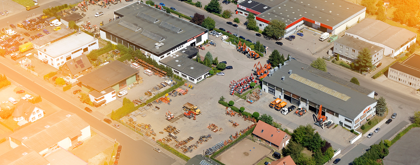 Luftaufnahme zeigt vom ATLAS-Industriegebiet mit Lagerhäusern, Baumaschinen und parkenden Fahrzeugen